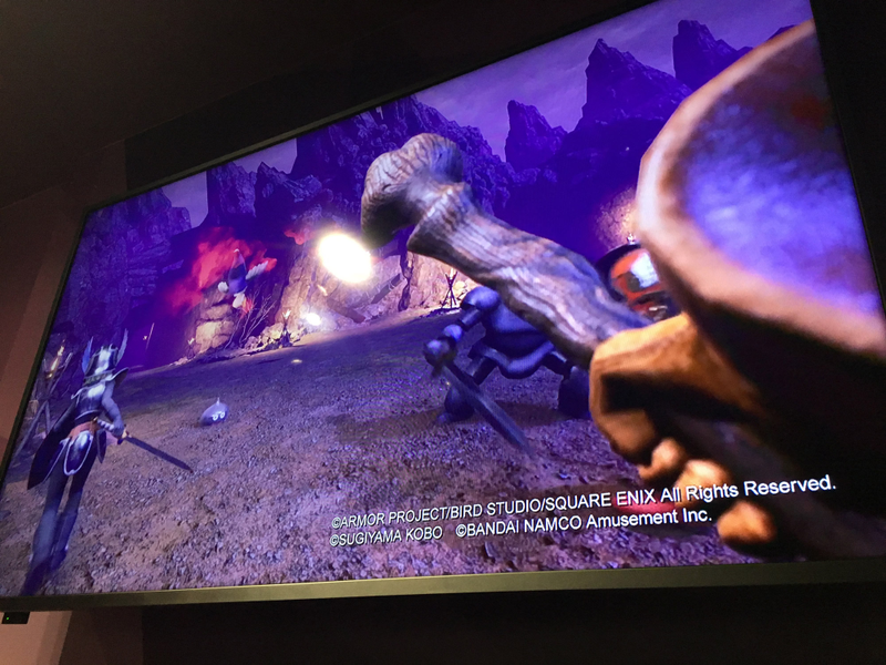 A trailer for Dragon Quest VR, with in-game imagery, is shown at the Shinjuku VR Zone where players wait to try the game.